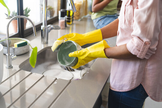 Biracial woman washing dishes at home