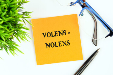 Willy - nilly latin expression volens-nolens (willing or unwilling) written on an orange sticker on...