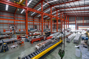 High angle view of a spacious industrial warehouse with machinery, materials, and equipment for manufacturing.