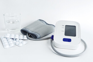 Automatic blood pressure monitor on white background. Digital blood pressure monitor and medicine...