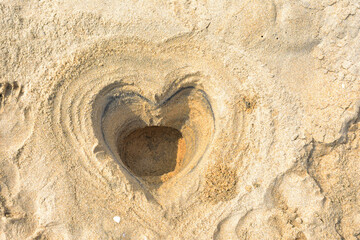 Heart shape dig on beach.