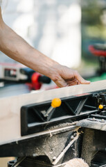 Carpenter precisely cutting wood with a miter saw.