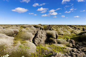 A rocky landscape with blue sky and clouds