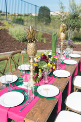 Tropical Theme Table Setting with Pineapples and Flowers