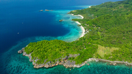 Rocky coastal with turquoise water and sandy beach in Cobrador Island. Romblon, Philippines.