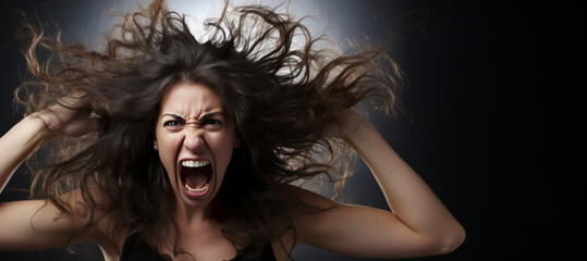 An enraged woman with her hair blowing in the wind. - obrazy, fototapety, plakaty