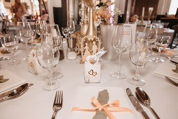 Coziness and style. Modern event design. Table setting at wedding reception. Floral compositions with beautiful flowers and greenery, candles, laying and plates on decorated table
