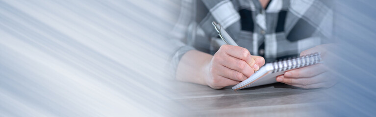 Female hands taking notes; panoramic banner