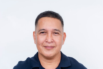 Fototapeta premium A cheerful middle-aged Asian man in a casual polo shirt with a faint smile, isolated on a pure white background.