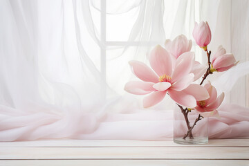 Pink magnolia flowers in glass vase near the window with tulle fabric