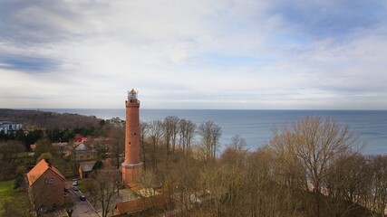 A drone captures Gąski beach, West Pomeranian Voivodeship, Poland, featuring a red brick lighthouse. © Grzegorz