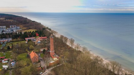 A drone captures Gąski beach, West Pomeranian Voivodeship, Poland, featuring a red brick lighthouse. © Grzegorz