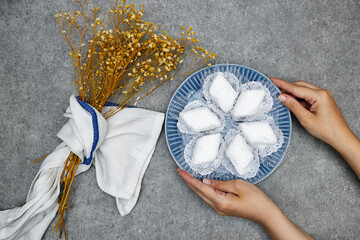 hands holding plate with algerian traditional cookies named makrout is a almond paste forming...