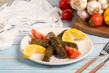 Stuffed grape leaves with olive oil. Appetizer dishes. Stuffed stuffed leaves with meat on a blue wooden background. local name yaprak sarma