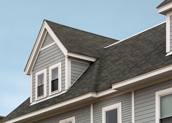 Detailed view of a gable-style dormer window on a sloped roof of a newly built family house in Brighton, MA, USA