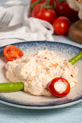 Olive oil and spicy appetizer. Appetizer dishes. Atomic dish with spicy yoghurt on blue wooden background. local name atom mezesi. Close up