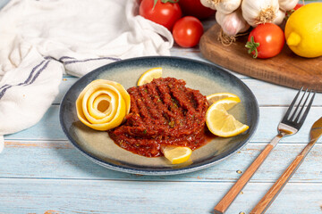 Spicy appetizer. Appetizer dishes. Spicy pate on blue wooden background. local name acılı ezme