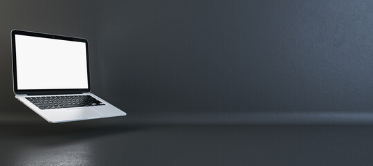 Wide-angle view of a silver laptop with a blank screen on a dark background, tech presentation...