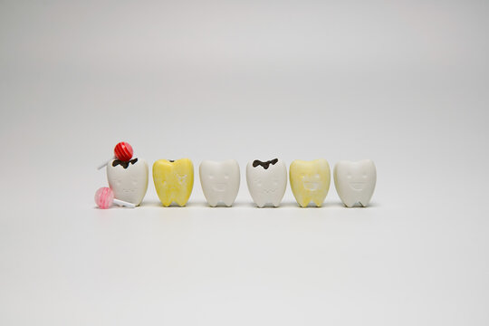 Whitening teeth, Yellow teeth and Cavity teeth with sweet candy on white background, Sweets cause tooth decay.
