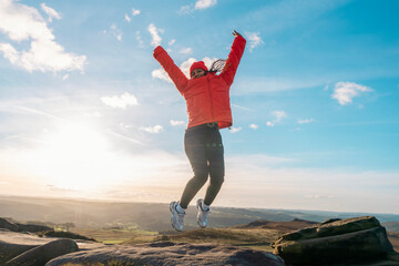 happy woman reaching destination, jumping, rising hands on top of mountain at the sunset.  Love,...