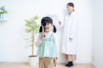 視力検査をする女の子と医者