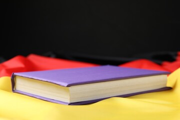 Learning foreign language. Book on flag of Germany, space for text