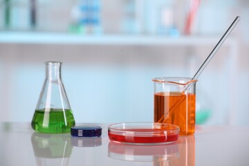 Laboratory analysis. Different glassware with liquids on white table against blurred background