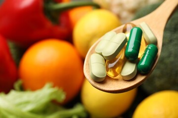 Dietary supplements. Spoon with different pills over food products, closeup. Space for text