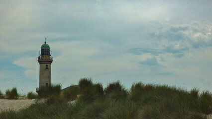 Sand dunes and maritime seascape coast view with lighthouse in Warnemunde Rostock, Germany at East...