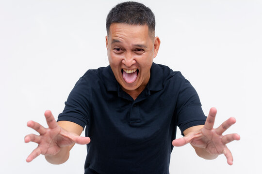 A lusty and pervy middle aged asian man reaching out with both hands, toungue out. Isolated on a white background.