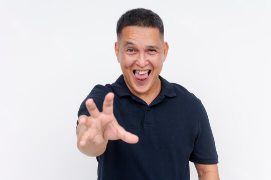 A lusty and pervy middle aged asian man reaching out with his hand, toungue out. Isolated on a white background.