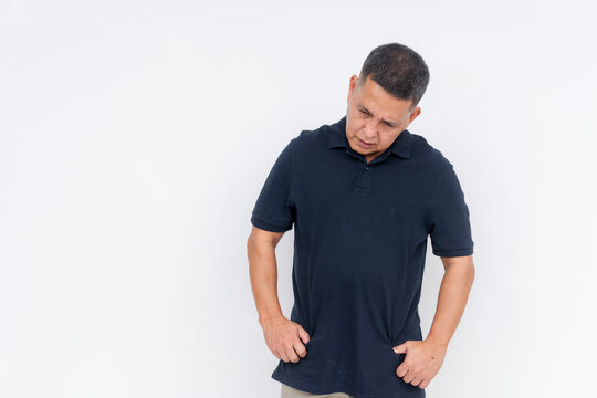 A middle-aged Asian man looking down with a guilty expression, conveying regret. Solemn mood, isolated on a white background. Copyspace on the left.