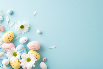 Easter fantasy depiction. Top view of decorated eggs, and tender blossoms on a pastel blue setting...