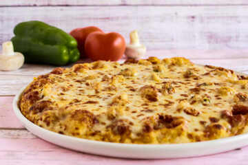 Mozzarella Pizza topping with capsicum, mushroom, tomato and olives served in dish isolated on table side view of arabic fastfood