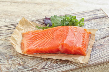 Raw salmon fillet over board
