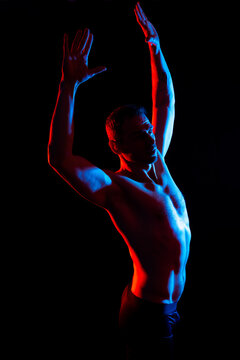 Image of muscle man posing in studio, dark white red background