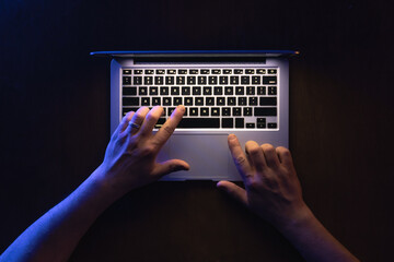 Top view of man hand using laptop at late night.