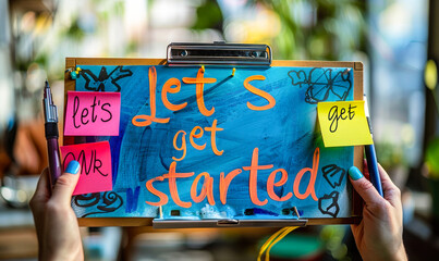Motivational sticky note: Let's get started, written in bold blue letters