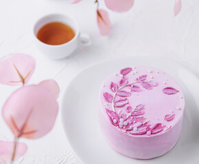 Piece of chocolate cake with pink cream and tea