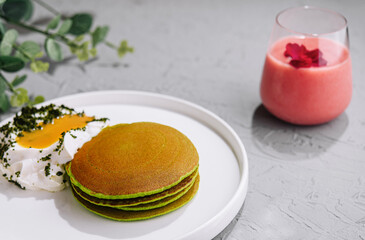 Green pancakes from spinach with sour cream and yolk