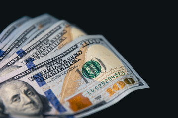 Close-up, American dollar bills on a black background.
