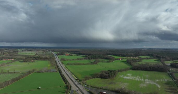 aerial footage of rainclouds moving away over the German E30 highway. Below you see Waldseite-Nord parking place.