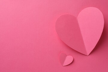Paper hearts on pink background, flat lay. Space for text