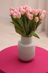 Beautiful bouquet of fresh pink tulips on table indoors