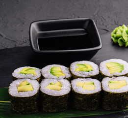 Delicious sushi maki with avocado on black