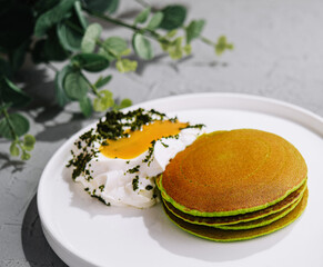 Green pancakes from spinach with sour cream and yolk