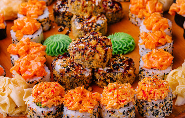Tasty appetizing sushi rolls set on wooden board