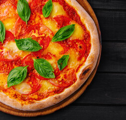 Pizza Margherita on black wood background