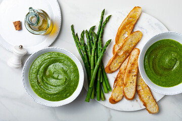 Healthy asparagus, green peas, watercress cream soup with toasted bread