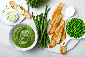 Healthy asparagus, green peas, watercress cream soup with toasted bread and wild garlic, ramson...